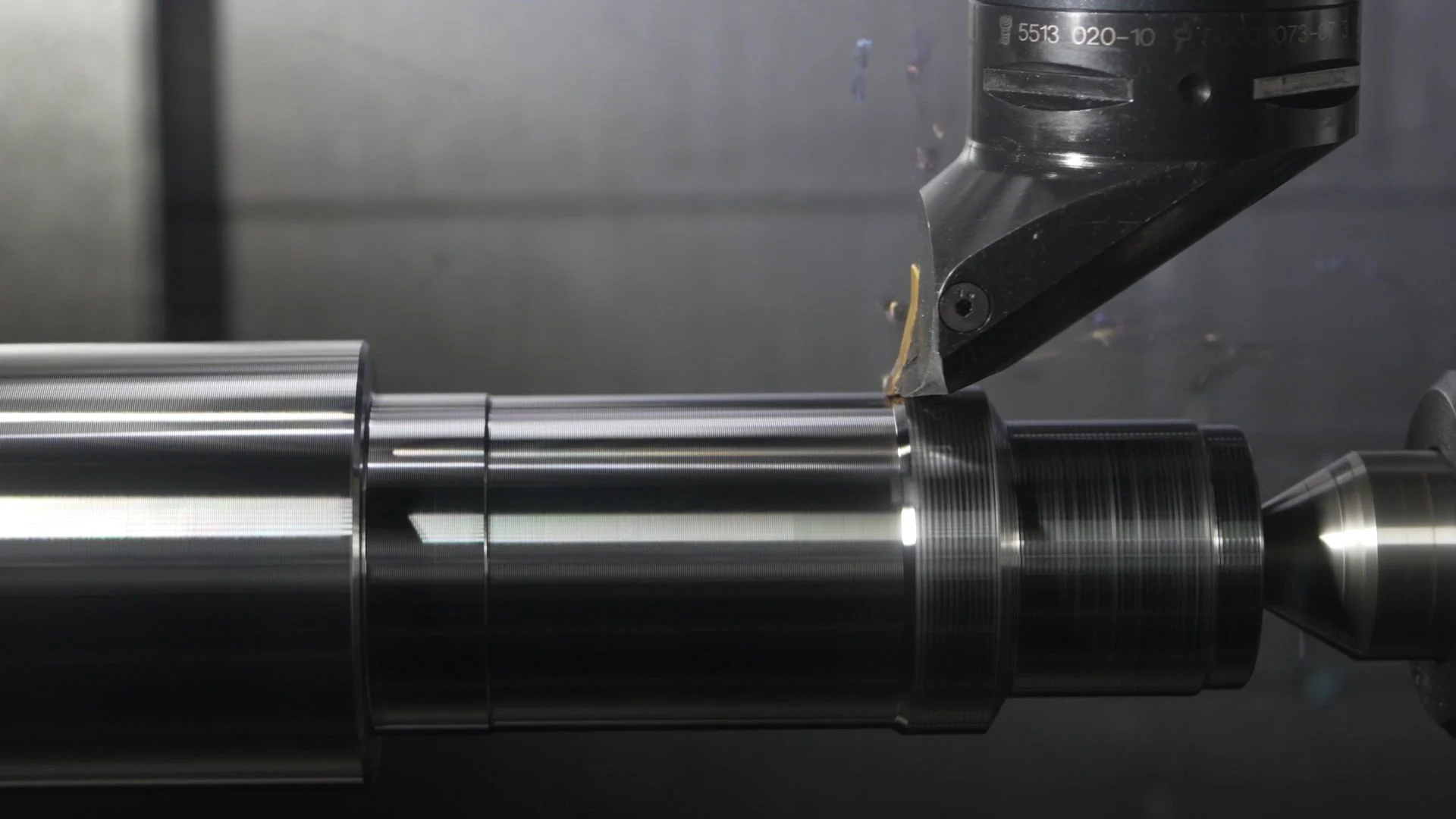 CNC torna tezgâhında dönen metal milin yüzeyini kesen sabit kesici uç